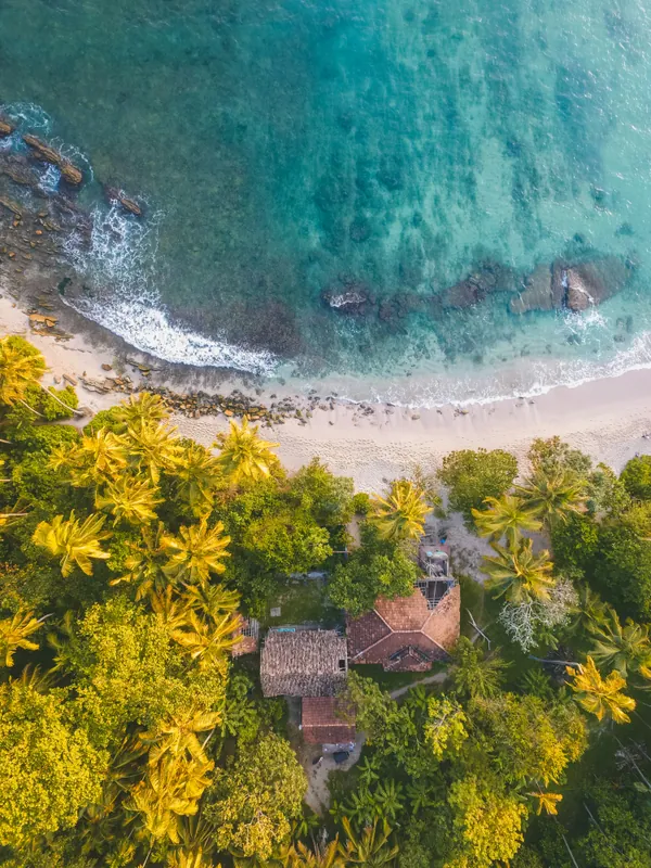 Aerial view of a villa among palms on a south coast beach in Sri Lanka