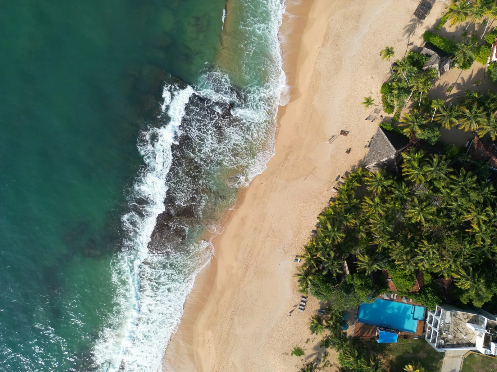 Aerial view of a wide golden-sand beach and turquoise bay at Tangalle, southern Sri Lanka